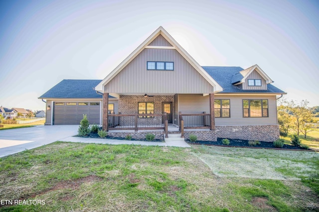 view of front of house with covered porch, a garage, and a front lawn