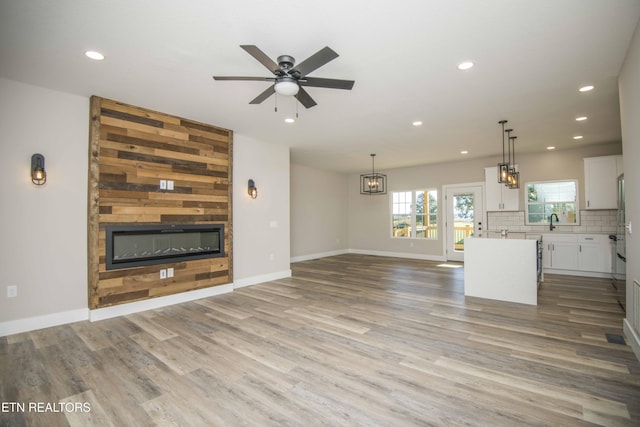 116 Duseth Dr, Sweetwater, TN 37874 - unfurnished living room with a large fireplace, recessed lighting, wood finished floors, ceiling fan, and a chandelier