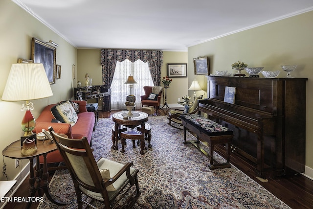 living area featuring baseboards, wood finished floors, and crown molding