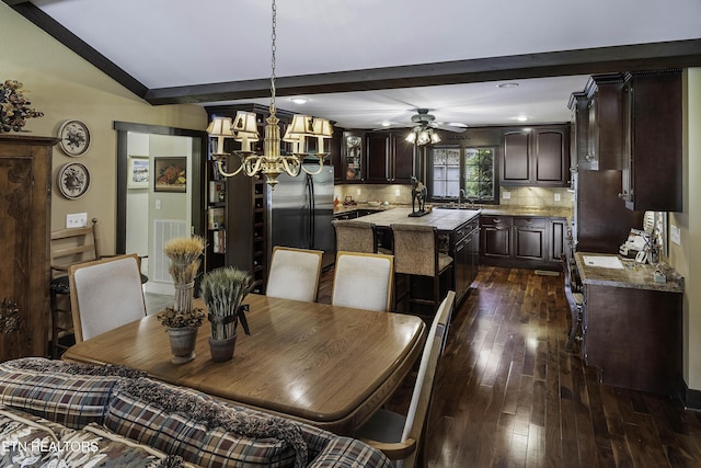 dining room featuring dark wood finished floors, beamed ceiling, ceiling fan with notable chandelier, and visible vents