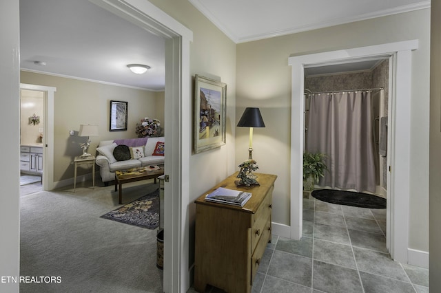 hallway featuring carpet flooring, baseboards, and ornamental molding