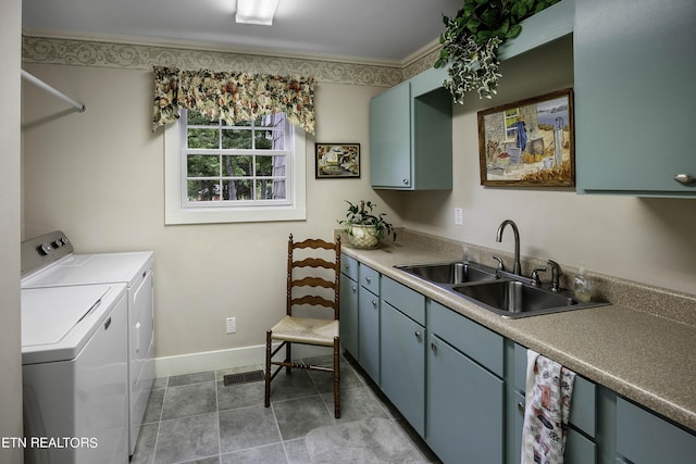 washroom with crown molding, baseboards, washer and clothes dryer, cabinet space, and a sink