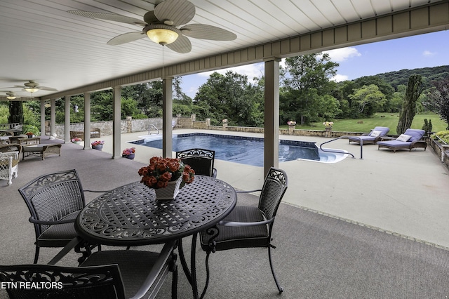 outdoor pool featuring a fenced backyard, a ceiling fan, outdoor dining area, and a patio