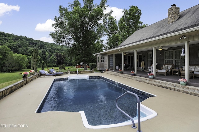 outdoor pool with a ceiling fan, a patio area, and an outdoor hangout area