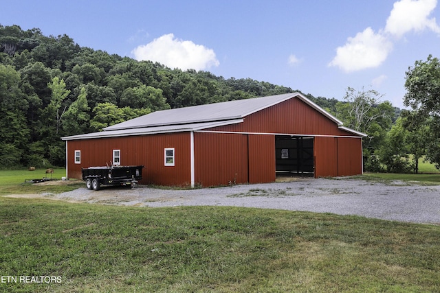 view of pole building featuring a yard and a view of trees