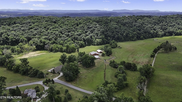 aerial view featuring a wooded view and a mountain view