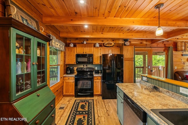 kitchen featuring black appliances, light hardwood / wood-style flooring, hanging light fixtures, french doors, and light stone counters