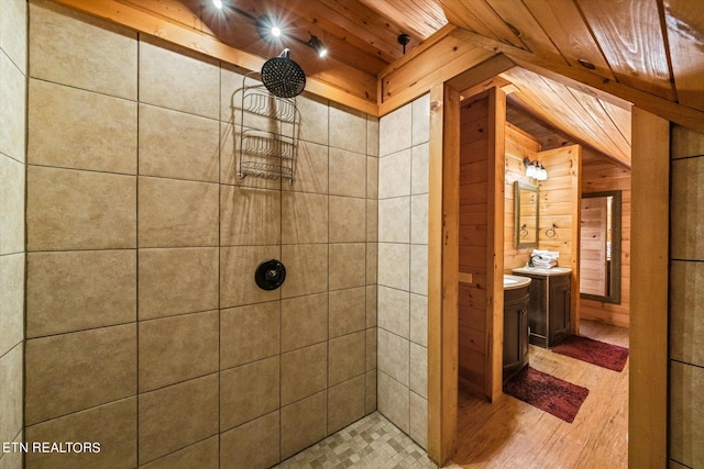 bathroom featuring vanity, wooden ceiling, wood walls, and tiled shower