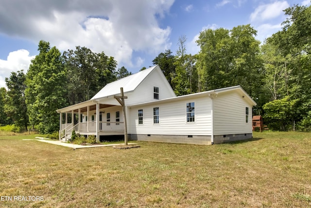 back of property with a porch and a yard