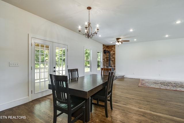 dining space with dark wood-type flooring, ceiling fan with notable chandelier, and french doors