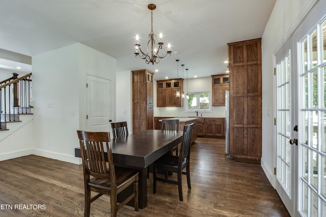 dining space featuring french doors, dark hardwood / wood-style flooring, and a notable chandelier