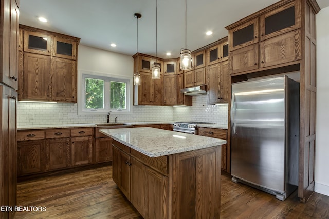 kitchen with appliances with stainless steel finishes, a kitchen island, dark hardwood / wood-style flooring, sink, and hanging light fixtures