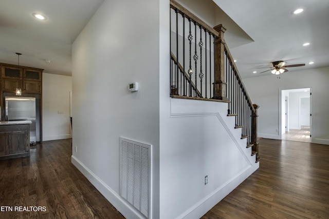 staircase featuring ceiling fan and hardwood / wood-style floors