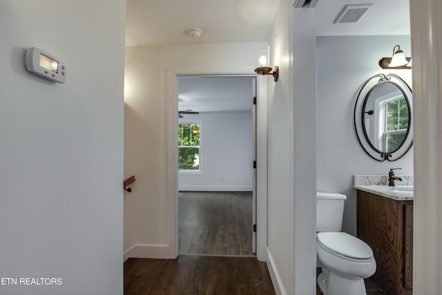 bathroom with toilet, ceiling fan, wood-type flooring, and vanity