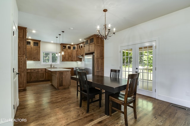 dining room featuring dark hardwood / wood-style floors, a chandelier, french doors, and sink