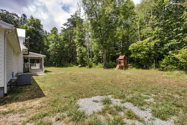 view of yard with a playground and central AC unit