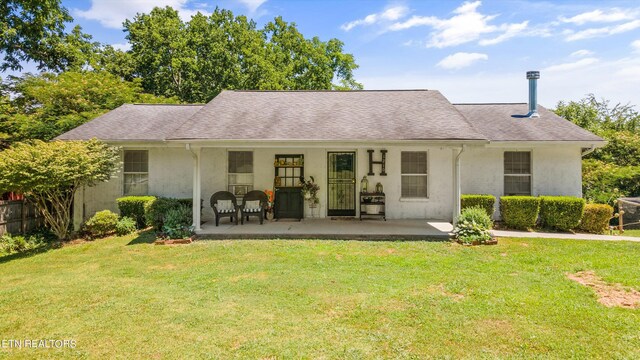 back of house with a lawn