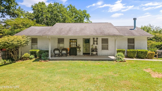 back of property with a lawn and a patio area