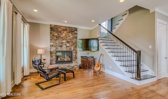 sitting room with a fireplace, light hardwood / wood-style floors, and ornamental molding