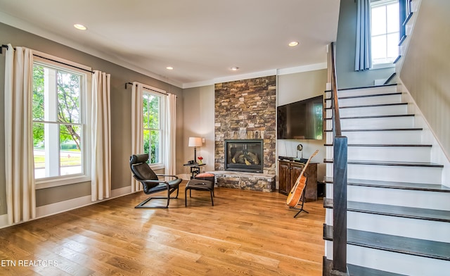 sitting room featuring light hardwood / wood-style floors, ornamental molding, and a fireplace