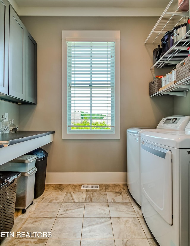 laundry room featuring light tile patterned flooring, cabinets, and separate washer and dryer