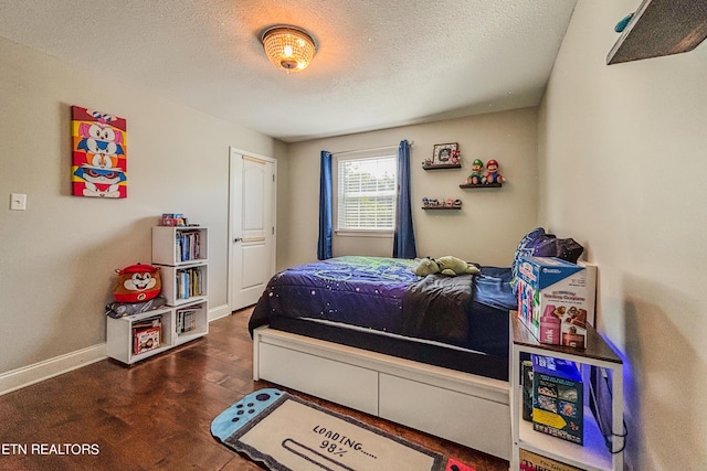 bedroom featuring dark wood-type flooring and a textured ceiling