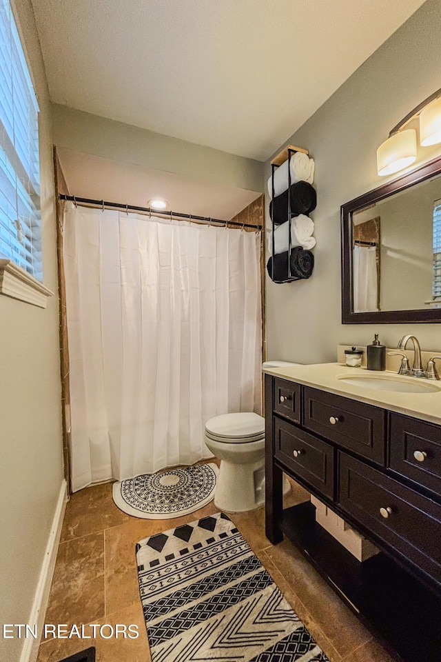 bathroom with toilet, tile patterned flooring, and vanity