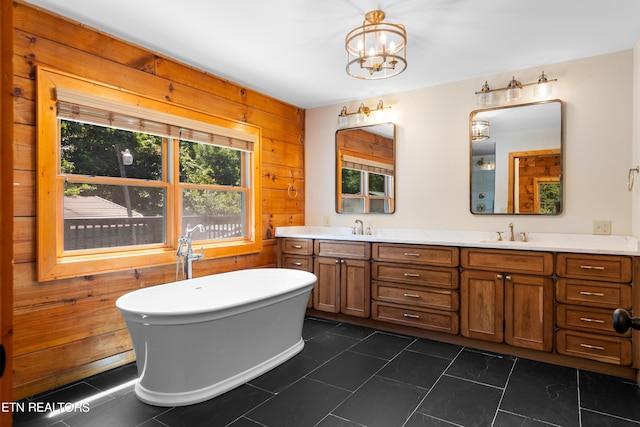 bathroom with a tub, tile patterned flooring, wood walls, a chandelier, and vanity