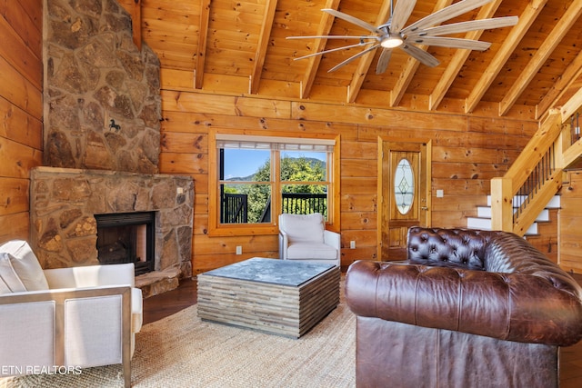 living room with beam ceiling, wooden ceiling, and wooden walls