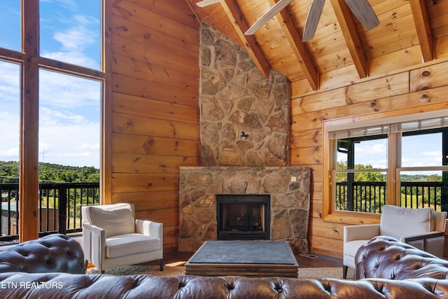 living room with wooden ceiling, wooden walls, ceiling fan, a fireplace, and beamed ceiling