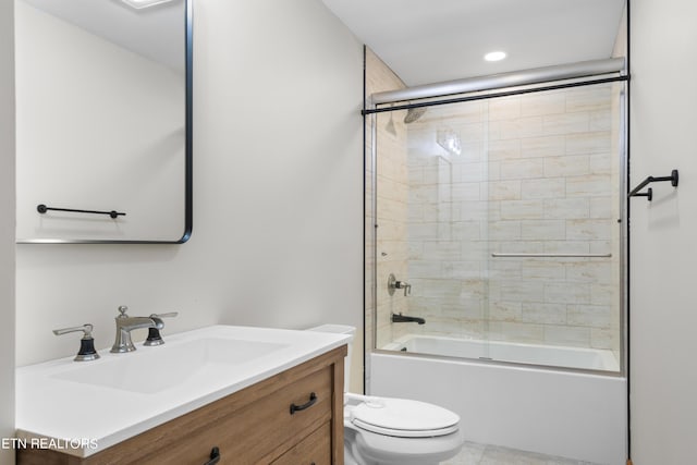 full bathroom featuring vanity, combined bath / shower with glass door, and toilet