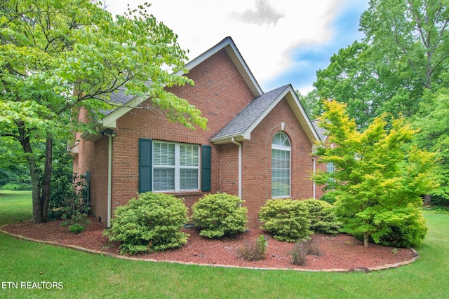 view of side of home with a yard