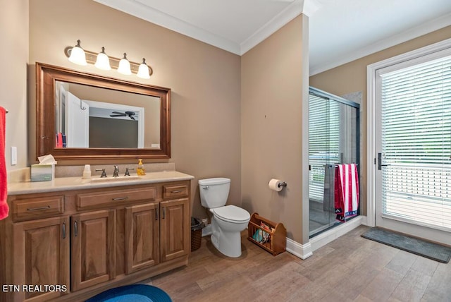 bathroom with ornamental molding, a shower with door, hardwood / wood-style floors, and vanity