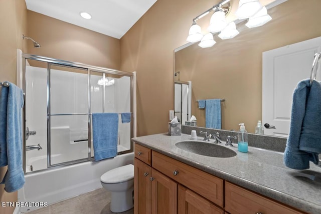 full bathroom featuring toilet, tile patterned floors, vanity, and shower / bath combination with glass door