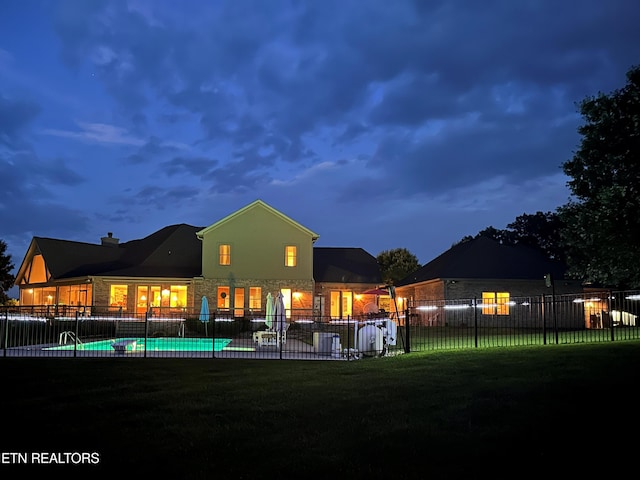 back of property with a fenced in pool