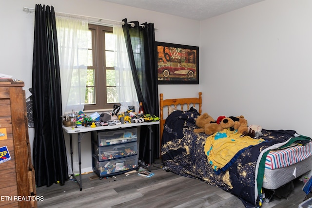 bedroom featuring wood-type flooring and a textured ceiling