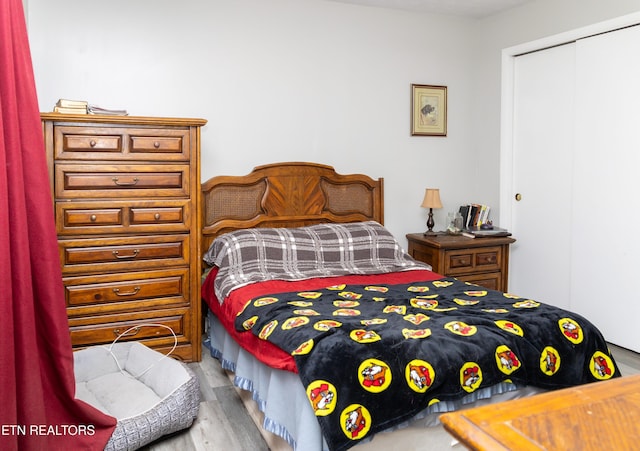 bedroom with light wood-type flooring and a closet