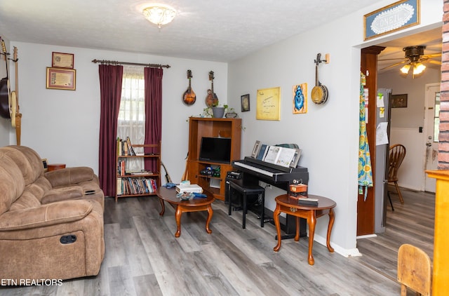 living room featuring ceiling fan, a textured ceiling, and hardwood / wood-style floors