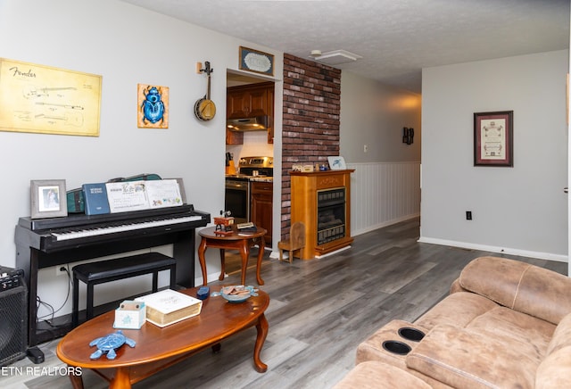 living room with a textured ceiling, a fireplace, and wood-type flooring