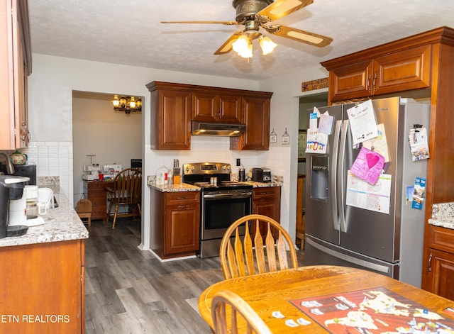 kitchen featuring ceiling fan with notable chandelier, a textured ceiling, appliances with stainless steel finishes, dark wood-type flooring, and backsplash