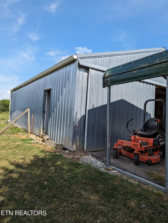 view of pole building featuring a carport and a lawn