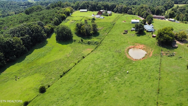 birds eye view of property featuring a rural view and a wooded view