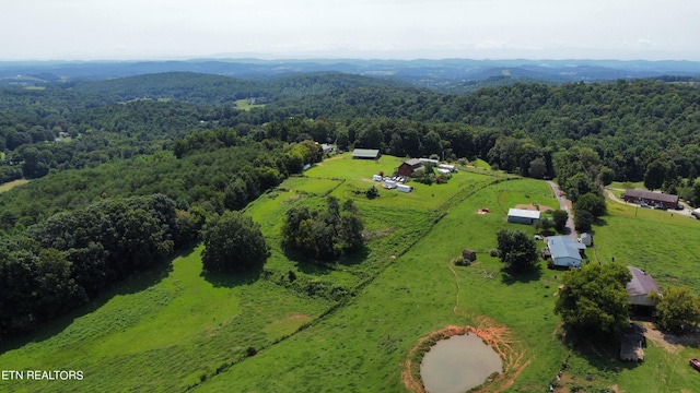 bird's eye view featuring a view of trees and a rural view