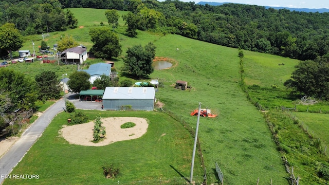 drone / aerial view with a wooded view and a rural view