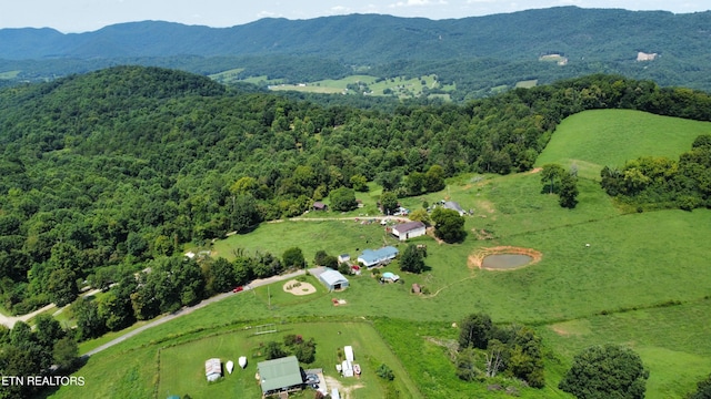 birds eye view of property with a mountain view and a wooded view