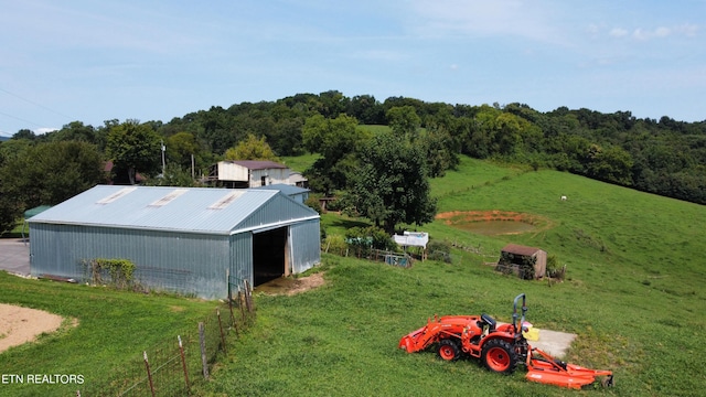 view of pole building featuring a yard and a forest view