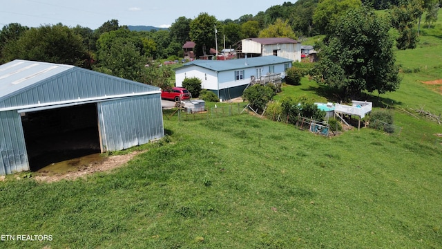 view of yard featuring a detached garage, an outbuilding, and an outdoor structure