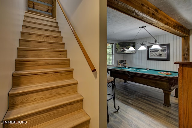 game room featuring wood-type flooring, pool table, a textured ceiling, and wooden walls