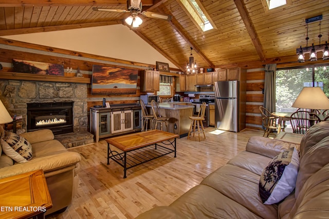 living room with a skylight, wood ceiling, ceiling fan, beam ceiling, and light hardwood / wood-style flooring