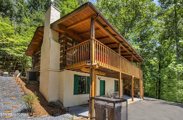 back of house with a wooden deck, central AC, and a patio